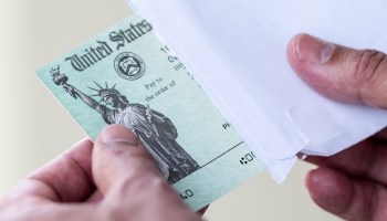 A man holds a U.S. government Treasury check.