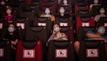 People watch a movie while wearing masks in Wuhan, China, on July 20.