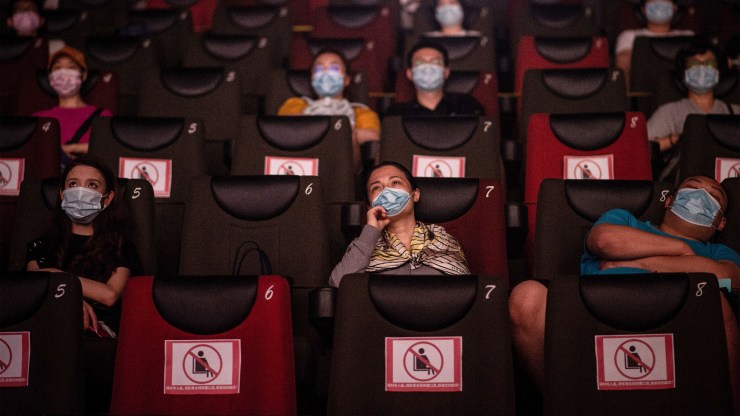 People watch a movie while wearing masks in Wuhan, China, on July 20.