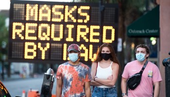 People wearing face masks stroll in Charleston, South Carolina. Decision-making can be influenced by the decisions of people you identify with.