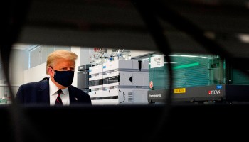 President Trump wears a mask as he tours a lab where they are making components for a potential vaccine in Morrisville, North Carolina.
