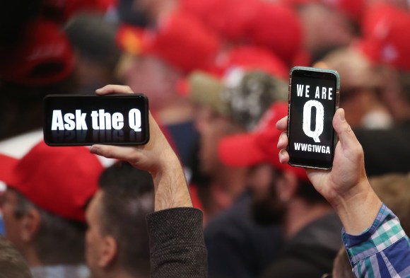 Supporters of President Donald Trump holding up their phones with messages referring to QAnon at a campaign rally at Las Vegas Convention Center on February 21, 2020.
