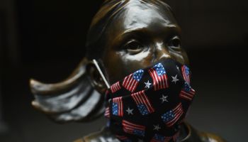 The "Fearless Girl" statue wears a face mask printed with American flags outside the New York Stock Exchange in April.