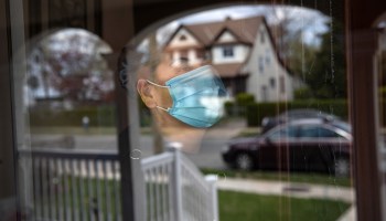 Salvadorian immigrant Ledis, quarantined at home with COVID-19, looks from her front door on April 16, 2020 in Long Island, New York.