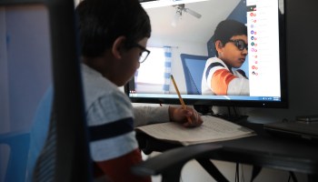 A second-grader using a webcam and computer to participate in distance learning because of the pandemic.