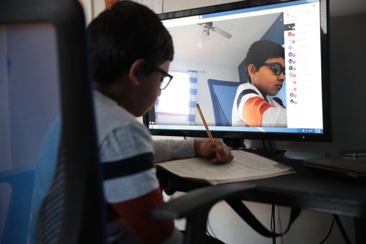 A second-grader using a webcam and computer to participate in distance learning because of the pandemic.