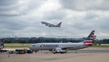 An American Eagle plane takes off while an American Airlines plane approaches a gate at Ronald Reagan Washington National Airport on July 10, 2020, in Arlington, Virginia.