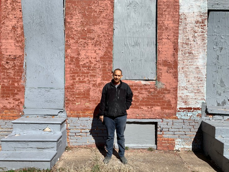 Shelley Halstead, 50, founder and executive director of Black Women Build, stands in front of some of the abandoned houses she's restoring in West Baltimore.