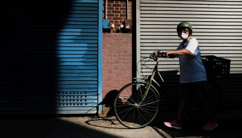 A person walks with a bike in New York City. The coronavirus pandemic battered bicycle manufacturing but boosted demand.