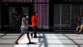 Customers wearing face masks walk past closed stores at a mall in Franklin, Tennessee.