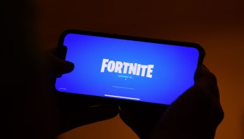 This illustration shows a person logging into Epic Games' Fortnite on their smartphone.