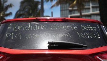 A message on a car window demands a better system for supporting unemployed workers in Florida.