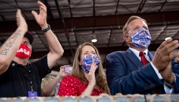 Supporters in Trump 2020 and MAGA face masks cheer for President Trump during a campaign rally Yuma International Airport on Aug. 18.