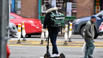 An Uber Eats delivery worker riding an electric scooter in New York City in March.