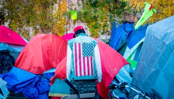 A man stands in the middle of tents amid the more than 200 people living at the large encampment along Hiawatha and Cedar Avenues in Minneapolis, Minnesota, on Oct. 22, 2018.