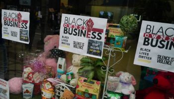 Signs in a shop window in Atlanta, Georgia, announce that a business is Black-owned.