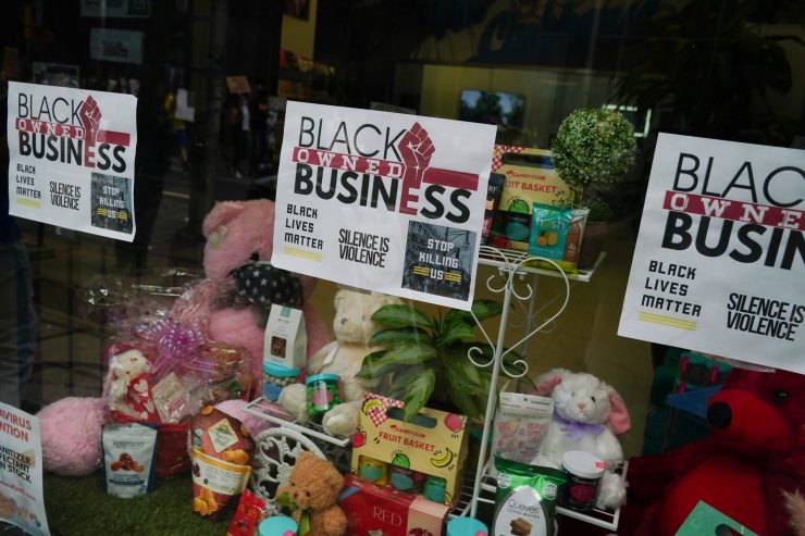 Signs in a shop window in Atlanta, Georgia, announce that a business is Black-owned.