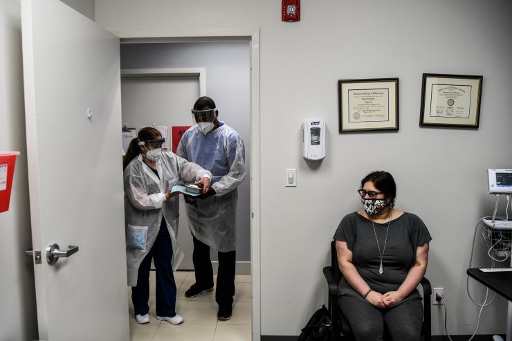 Volunteer Heather Lieberman, 28, sits while Yaquelin De La Cruz and Hari Leon Joseph arrive with a COVID-19 vaccine at the Research Centers of America in Hollywood, Florida, on August 13, 2020.