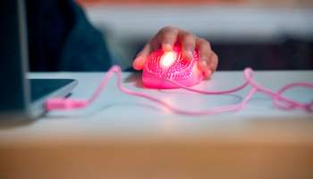 A student's glowing, pink computer mouse is seen as they follow along with their teacher's online lesson on September 10, 2020 in Culver City, California.