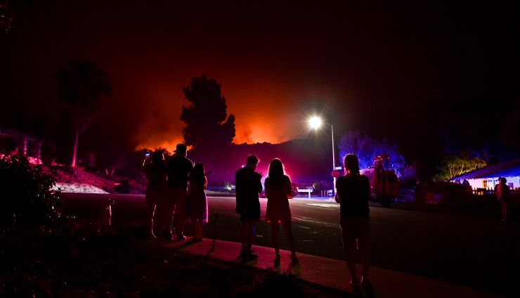 People watch as the Bobcat Fire burns on hillsides behind homes in Arcadia, California, on Sept. 13.