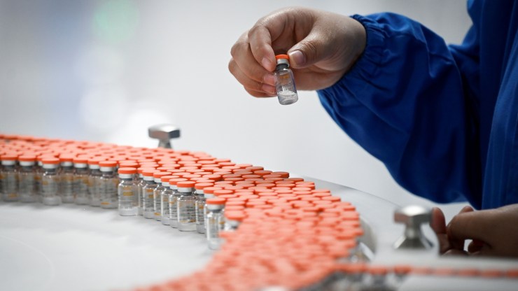 A staff member works during a media tour of a new factory built to produce a COVID-19 coronavirus vaccine at Sinovac, one of 11 Chinese companies approved to carry out clinical trials of potential coronavirus vaccines, in Beijing on September 24, 2020.
