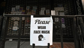 A sign reading "Please Wear Face Mask" hangs outside a temporarily closed Posh in Hell's Kitchen on June 22, 2020 in New York City.