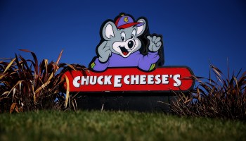 A sign with Chuck E. Cheese's mascot in front of a Chuck E. Cheese restaurant in Newark, California.