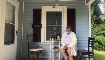 Marilyn Hoffman, sitting on the porch of her North Carolina home. She's able to stay... for now.