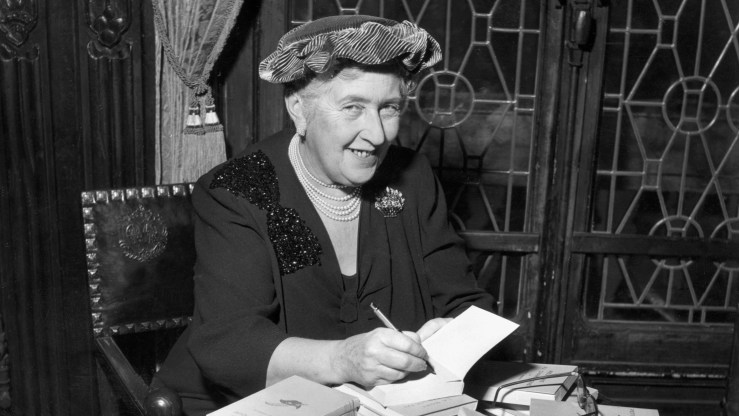 British mystery author Agatha Christie autographing French editions of her books, circa 1950.