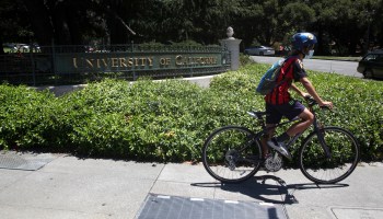 A cyclist rides by a sign in front of the UC Berkeley campus on July 22, 2020 in Berkeley, California.