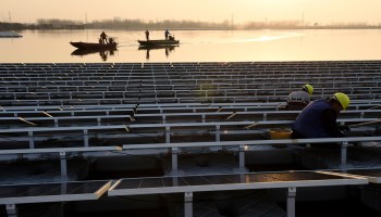 Employees work on a floating solar power plant in Huainan, a former coal-mining region, in China's eastern Anhui province in 2017.