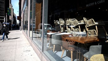 Chairs are stacked at a closed cafe in New York.
