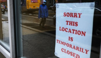 A sign on the door of a business letting customers know the store location is temporarily closed.