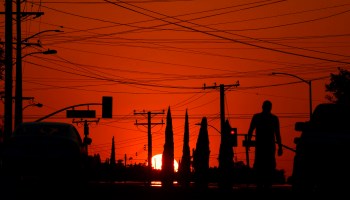 The sun sets behind power lines in Los Angeles.