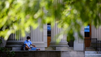A student in a face mask studies outside the closed Wilson Library on the campus of the University of North Carolina at Chapel Hill on Aug. 18.