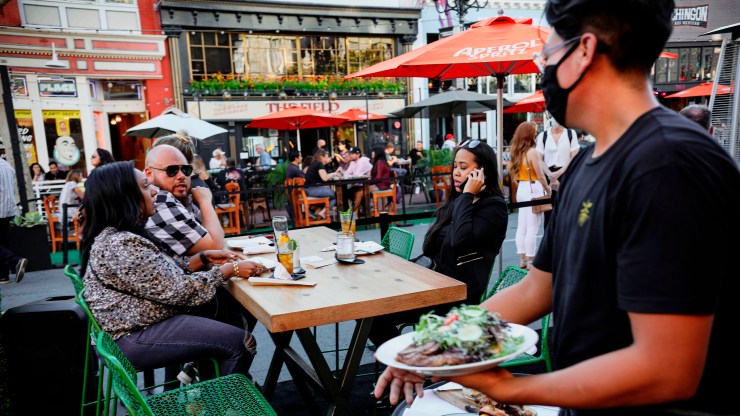 Patrons dine at an outdoor restaurant in downtown San Diego, California, in July.