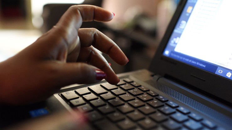 A woman types on a laptop.