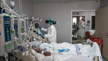 Medical staff wearing full PPE treats a patient in the COVID-19 intensive care unit at the United Memorial Medical Center in Houston, Texas.