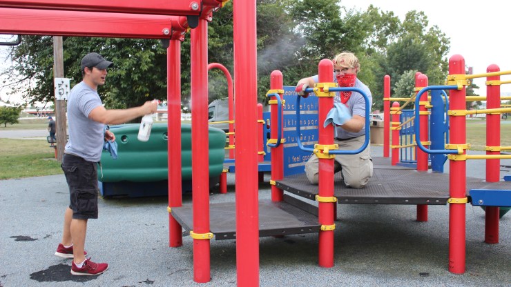 A two-person crew sprays down the playground at McIntosh Park in Dayton, Ohio.