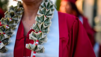 A graduating student wears a money lei, a necklace made of U.S. dollar bills, at the Pasadena City College graduation ceremony, June 14, 2019, in Pasadena, California.