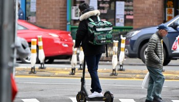 An Uber Eats delivery worker is seen riding an electric scooter in Manhattan's Chinatown on March 19, 2020 in New York City.