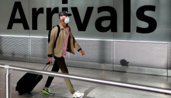 A traveler walks down a terminal at Heathrow Airport.