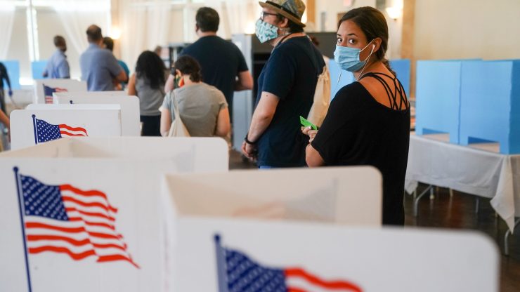 People wearing face masks wait in line to vote in Georgia's primary election earlier this year.