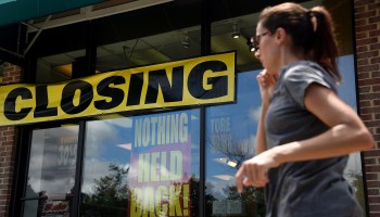 A woman walks past a store displaying a sign before closing down permanently following the impact of the coronavirus pandemic, on August 4, 2020 in Arlington, Virginia.