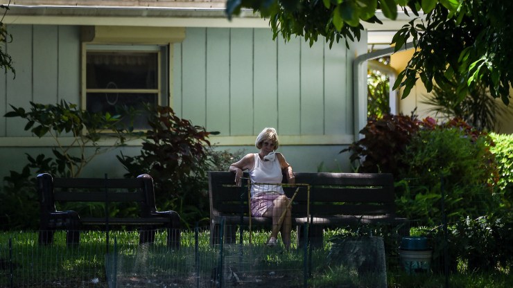 An elderly woman sits in the garden of John Knox Village, a retirement community in Pompano Beach some 40 miles north of Miami, Florida on August 7, 2020.