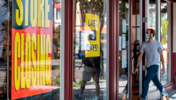 "Store Closing" signs are posted at a Sur La Table, kitchenware store, as people walk by on September 22, 2020, in Los Angeles, California.