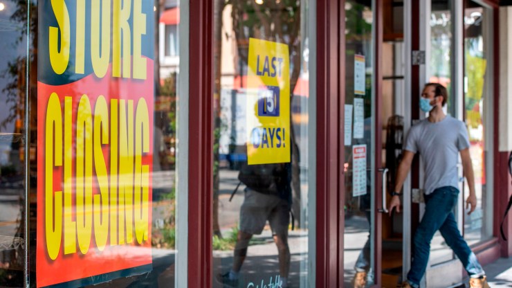 "Store Closing" signs are posted at a Sur La Table, kitchenware store, as people walk by on September 22, 2020, in Los Angeles, California.