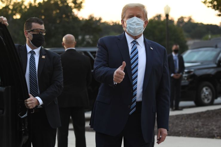 President Donald Trump gestures after walking out of Walter Reed Medical Center in Bethesda, Maryland before heading to Marine One on October 5, 2020, to return to the White House after being discharged.