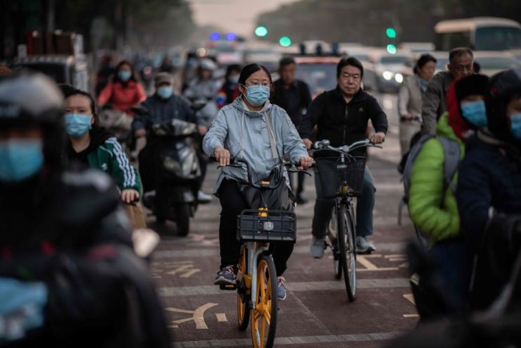 Commuters wear face masks to protect against COVID-19 during rush hour in Beijing on Oct. 15.