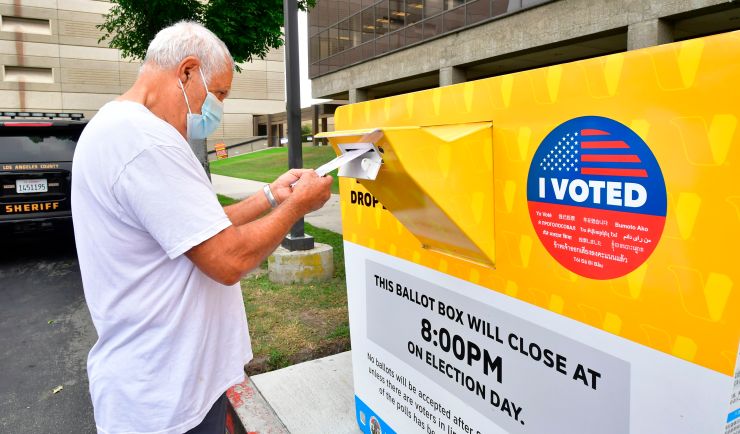 A voter drops his ballot for the 2020 US elections into an official ballot drop box at the Los Angeles County Registrar in Norwalk, California, on Oct. 19.